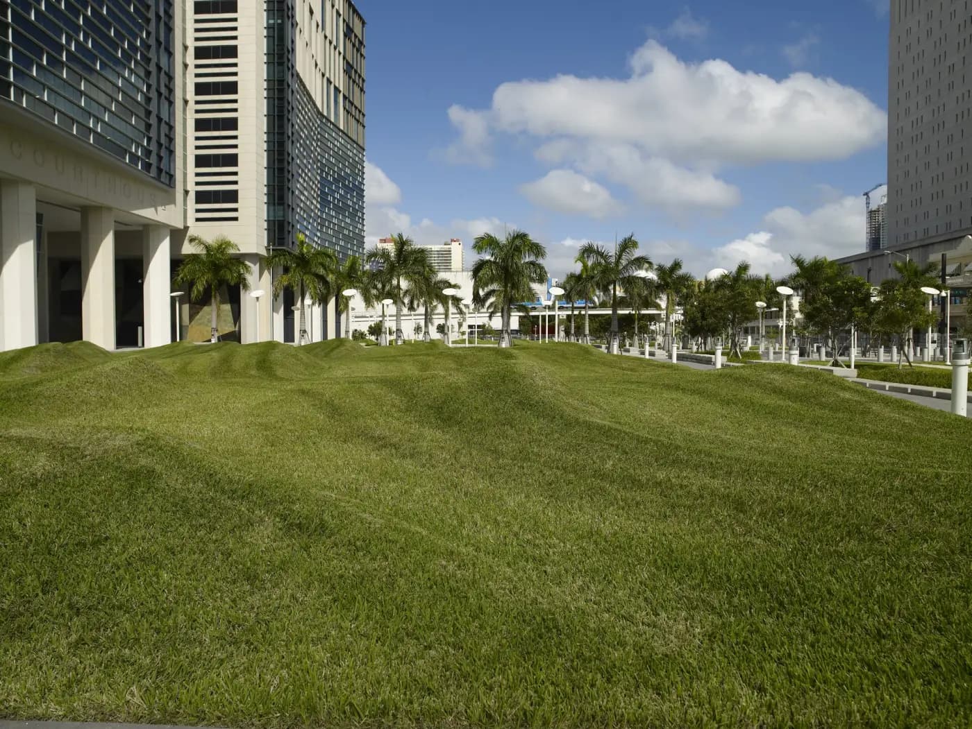 The lawn and columned entrance of the Wilkie D. Ferguson Jr. United States Courthouse in Miami, palm trees behind, with the word Courthouse carved above the entrance.